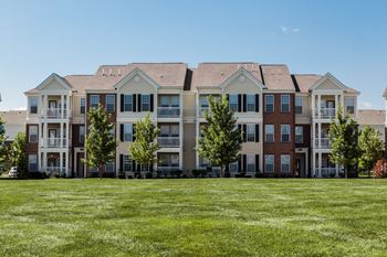 An image of an apartment building on a green lawn